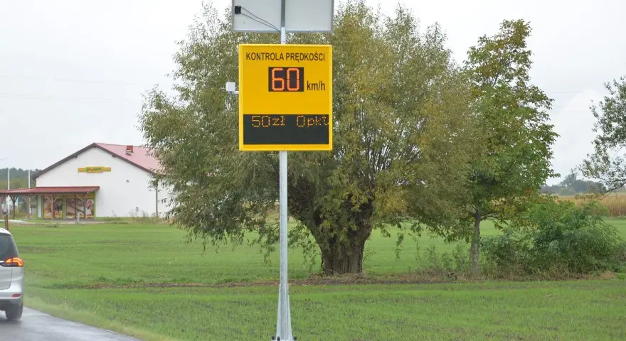 Tablica informuje o kontroli prędkości: 60 km/h, mandat 50 zł. To przypomnienie o taryfikatorze mandatów.