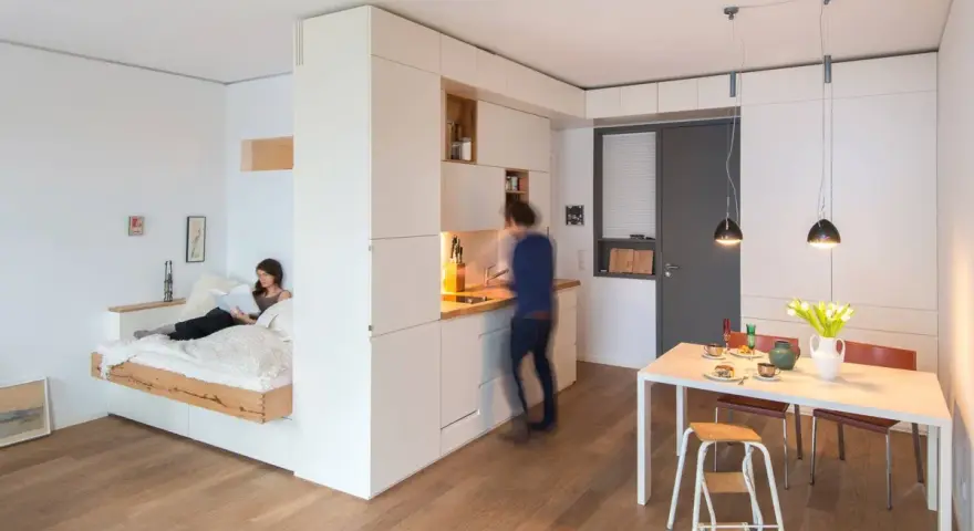 Un letto sospeso, una cucina moderna e un tavolo da pranzo creano un ambiente accogliente in queste case piccole bellissime.