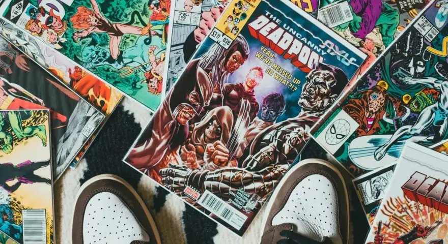 Kolekcja komiksów Marvela, w tym "The Uncanny X-Men" i "Deadpool", leży na dywanie. Idealne dla tych, którzy chcą wiedzieć, jak czytać komiksy Marvela.