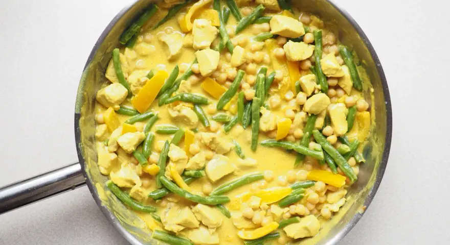 Pyszne, aromatyczne **yellow curry** z kurczakiem, fasolką szparagową i ciecierzycą w kremowym sosie.