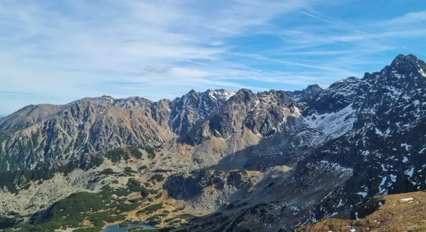 Majestatyczne Tatry z ośnieżonymi szczytami. Widok na skaliste zbocza i doliny, gdzie widać, ile ma Kasprowy Wierch.