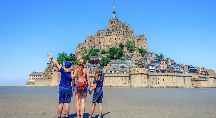 Famille en visite à Mont Saint-Michel, émerveillée par le château perché sur son îlot rocheux.