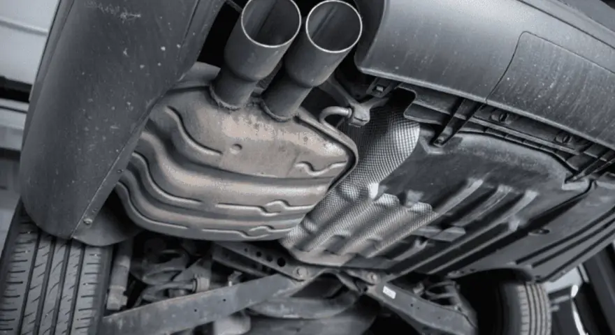 The underside of a car shows a dual exhaust system leading to a large muffler, which is a key component for reducing engine noise.