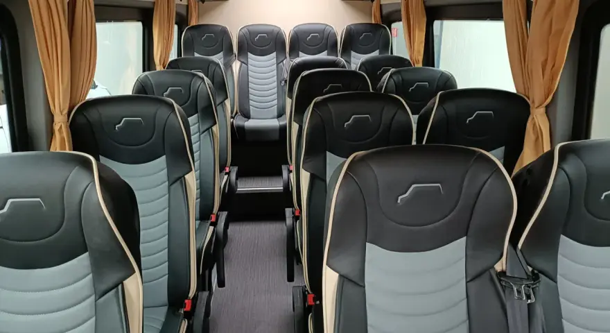 Wnętrze busa z wygodnymi, dwukolorowymi siedzeniami. Idealne do spedycji na busa, zapewniają komfort podróży.