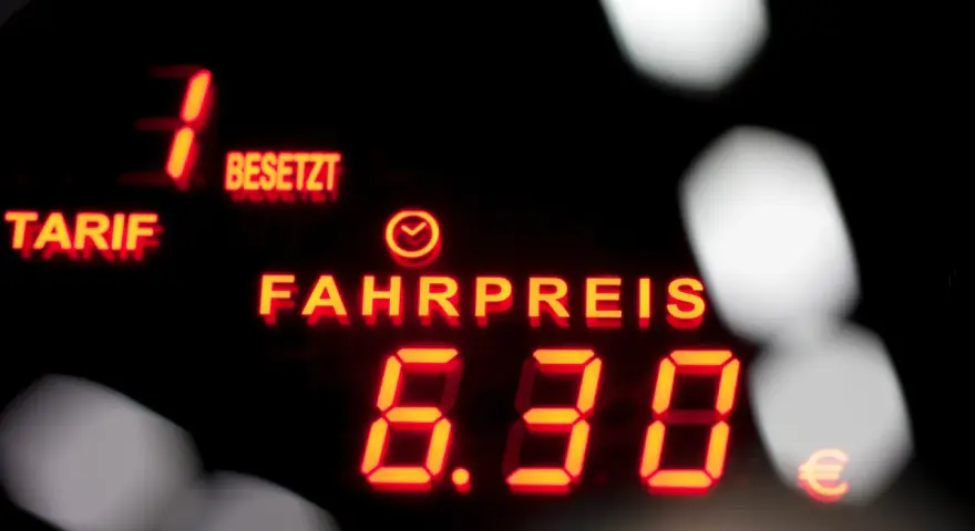 Rotes Leuchtdisplay zeigt "FAHRPREIS 6.30 €". Der taxameter preis ist klar ersichtlich.