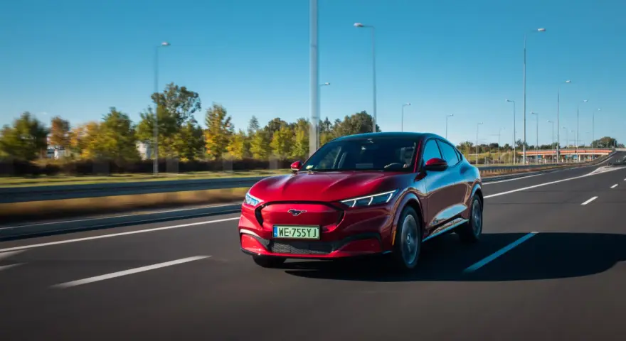 Czerwony Ford Mustang Mach-E jedzie po autostradzie w Polsce.