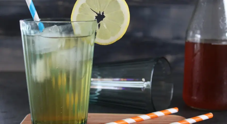 Erfrischender Eistee mit Zitrone, Eis und einem blauen Strohhalm. Perfekt, wenn du Eistee Sirup selber machen möchtest.