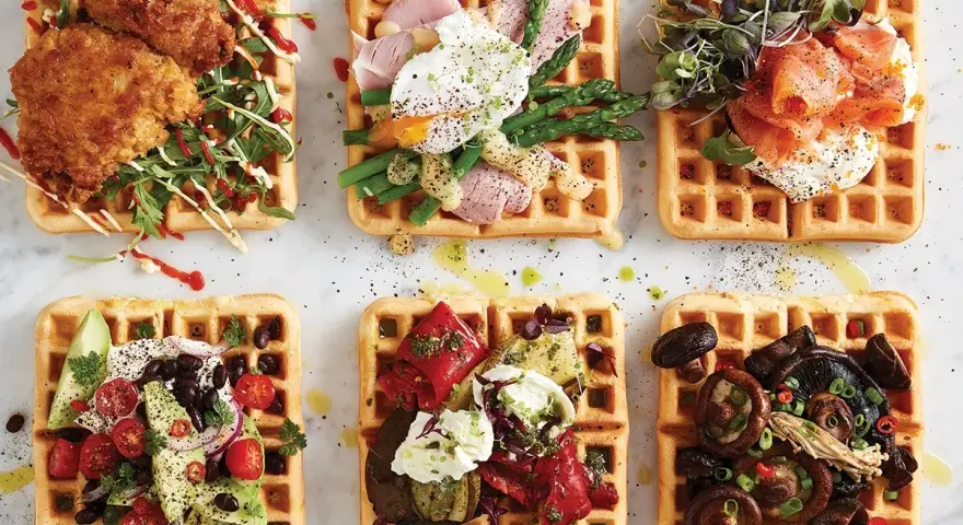 Sex olika protein våfflor: friterad kyckling, pocherat ägg med sparris, rökt lax, avokado och bönor, grillade grönsaker, och svamp.