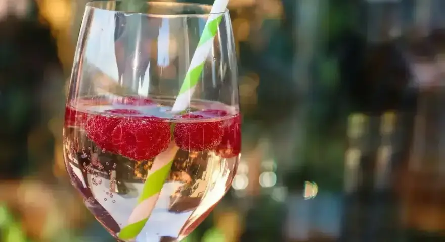 Orzeźwiający drink z malinami i słomką. Idealny na lato, gdy zastanawiasz się, z czym pić bacardi malinowe.