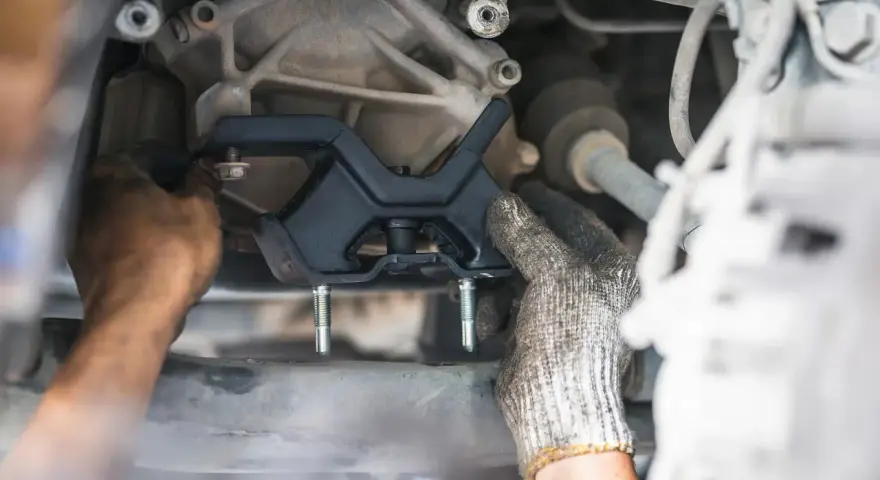 Mechanic installing a new engine mount. This repair is essential for smooth driving and can impact motor mount replacement cost.