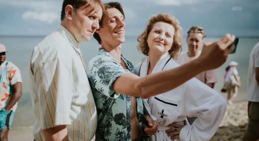 Trzech bohaterów z filmu "Teściowie 2" robi selfie na plaży. Gdzie obejrzeć ten hit?
