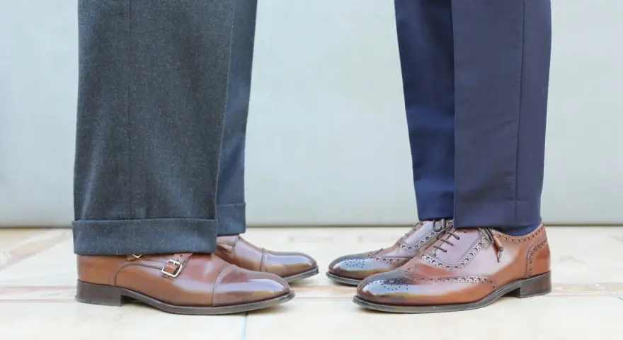 Długość spodni garniturowych: jeden model ma wywinięte nogawki, drugi gładkie. Eleganckie buty męskie.