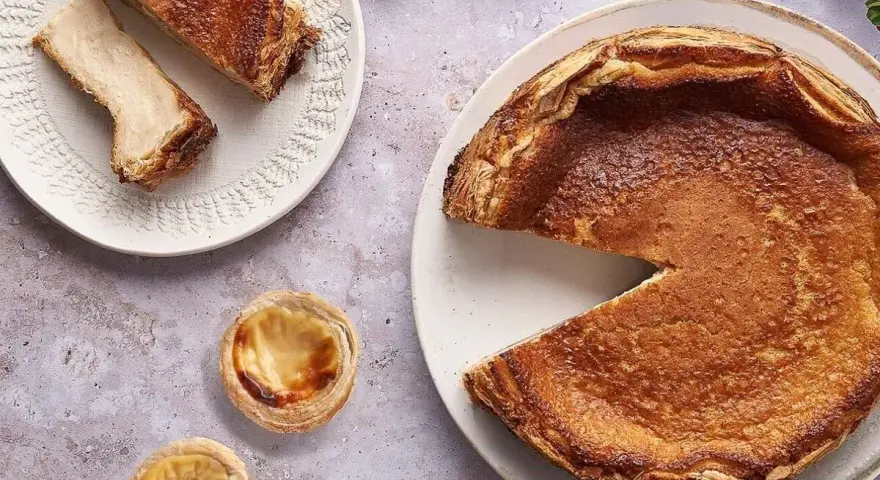 Un pastel de arroz dorado y crujiente, con dos porciones en un plato y dos pastelitos individuales.