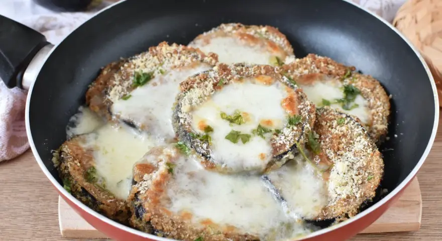Melanzane in padella con pangrattato e formaggio filante, un piatto gustoso e facile da preparare.