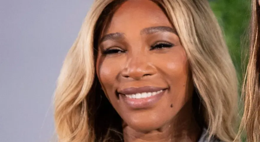 La tenista Serena Williams sonríe con su cabello rubio ondulado.