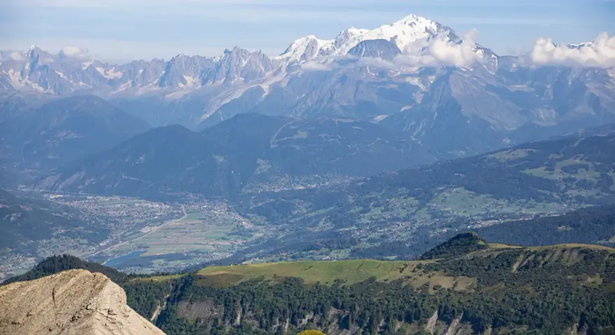 Vue panoramique des Alpes, avec le Mont Blanc enneigé, point culminant des Alpes, dominant la vallée verdoyante et ses villages.