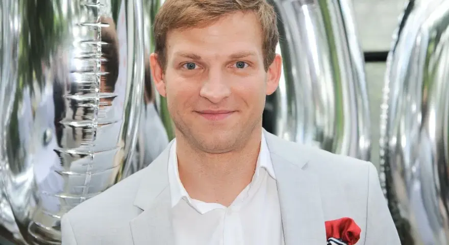 Michał Rolnicki z żoną na tle srebrnych balonów.