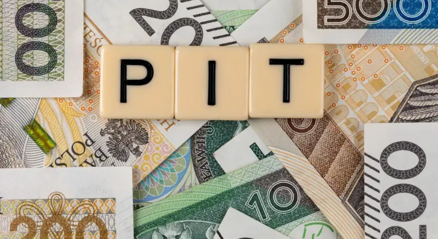 Litery "PIT" na tle polskich banknotów o różnych nominałach.