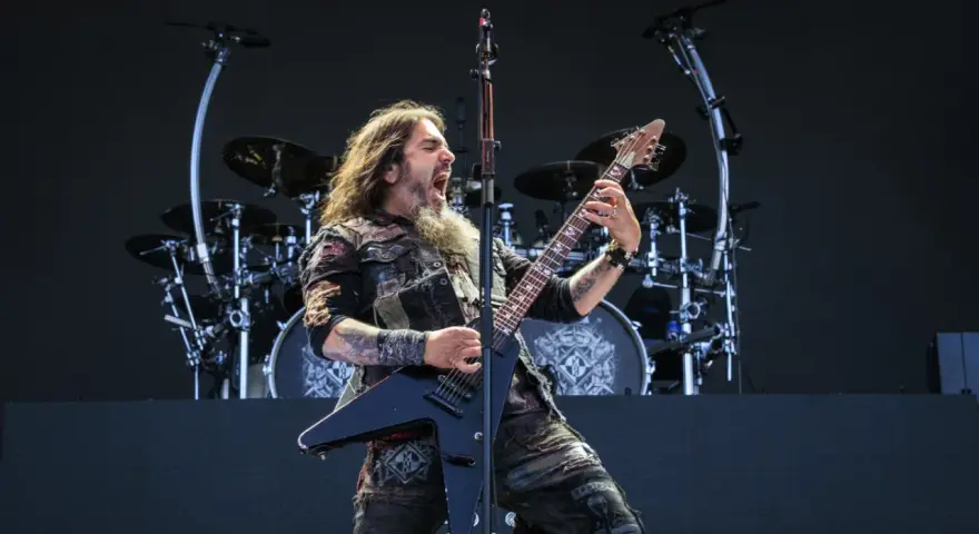 Robb Flynn z Machine Head na jednym z koncertów, w pełni energii, szaleje na czarnej gitarze typu V.