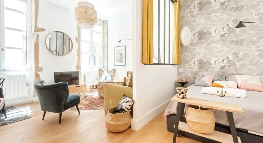 Une belle idée séparation chambre salon avec un mur décoré de nuages et un coin salon cosy.
