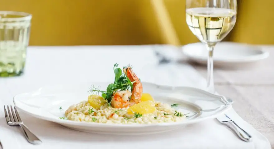 En krämig risotto med räkor och apelsin, perfekt ackompanjerad av ett glas vitt vin till risotto.
