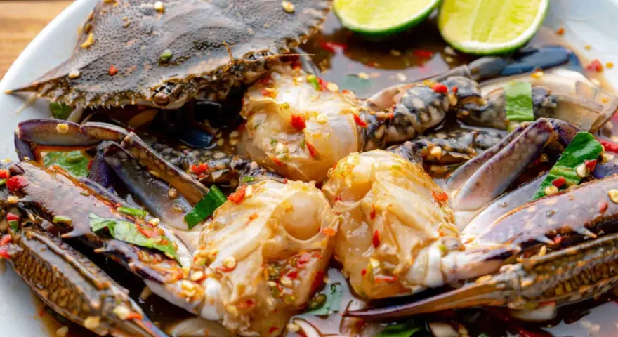 Un piatto di granchio blu crudo marinato con lime, peperoncino e erbe aromatiche. Un sapore intenso e piccante.