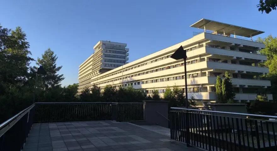 Nowoczesny budynek z tarasami, otoczony zielenią, idealny dla szukających najlepszych sanatoriów w Polsce.