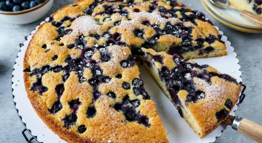 Saftiger Blaubeerkuchen, gebacken nach Omas Rezept. Mit Puderzucker bestäubt und voller Blaubeeren.