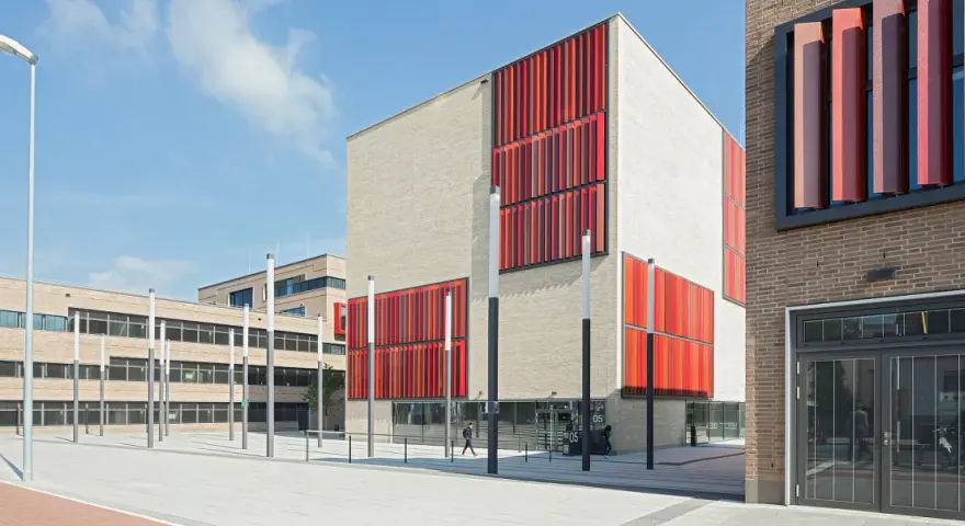 Moderne Gebäude der Hochschule Essen mit hellen Ziegelwänden und auffälligen roten Fassadenelementen.