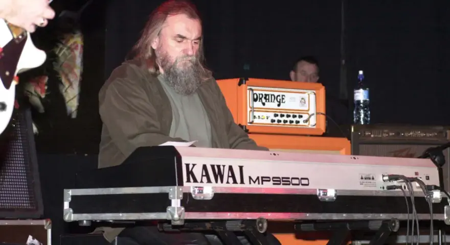 Klawiszowiec zespołu Dżem, z charakterystyczną brodą, gra na keyboardzie Kawai MP9500.
