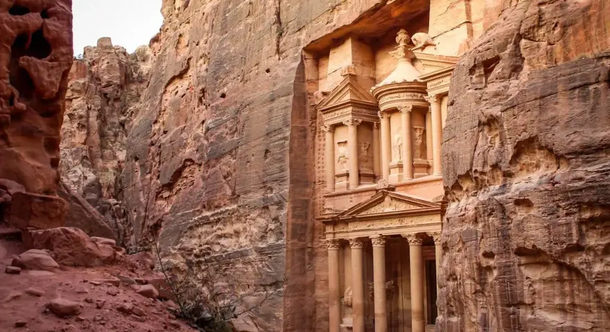 The Treasury in Petra, Jordan, emerges from a narrow canyon. It's a long journey, but how far is Petra from Amman? This ancient city is worth the trip.