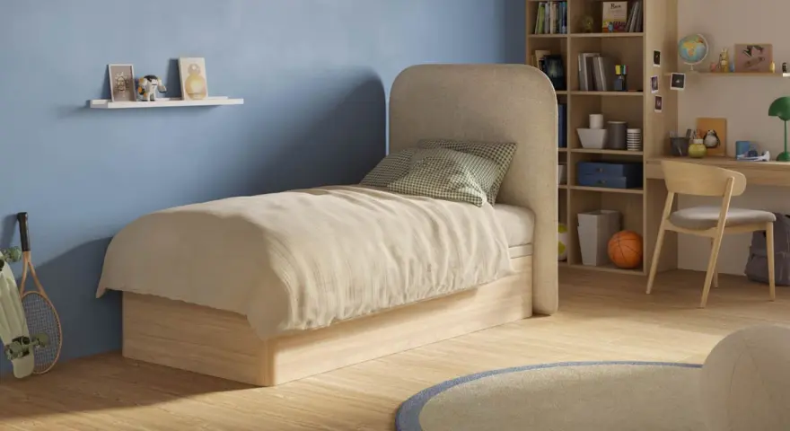 Chambre d'ado avec un matelas confortable, une étagère murale décorée et une bibliothèque remplie de livres et de jouets.