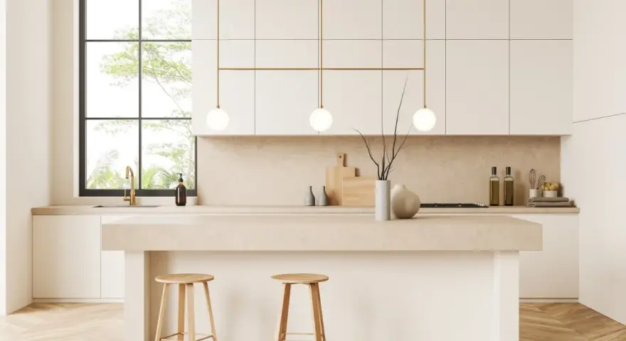 Cocina moderna y luminosa con isla central, taburetes de madera y detalles dorados. Perfecta para decorar cocina con estilo minimalista.