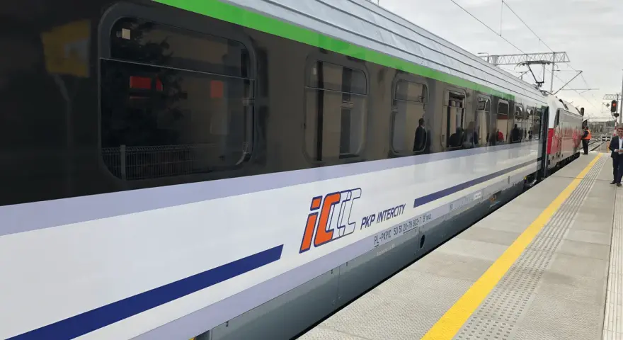 Pociąg PKP Intercity z charakterystycznym logo eic a ic stoi na peronie.