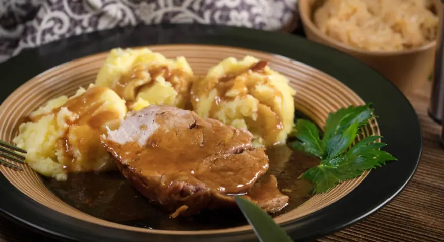 Soczysta karkówka w sosie sojowym, podana z purée ziemniaczanym i surówką. Pyszny obiad gotowy do spożycia.