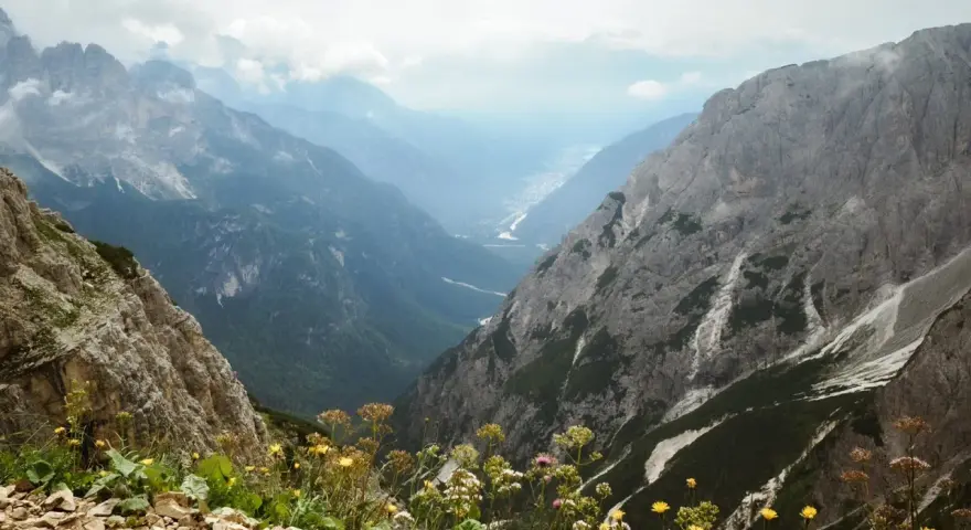 Widok z górskiej ścieżki na dolinę. Czy dolomity to Alpy? Tak, te skaliste szczyty i zielone doliny wyglądają jak Alpy.