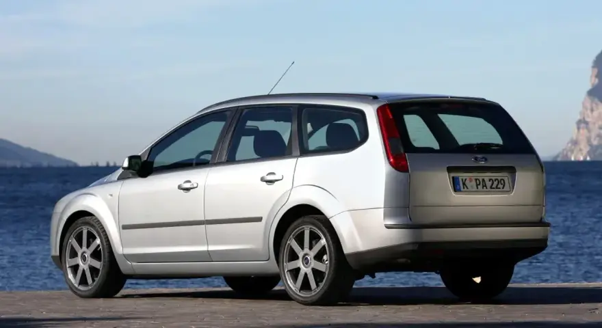 Srebrny Ford Focus MK2 1.6 benzyna na tle morza i skał.