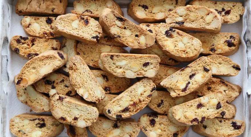 Un vassoio pieno di croccanti biscotti toscani, ricchi di mandorle e mirtilli rossi, pronti per essere inzuppati.