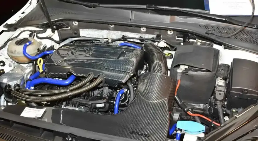 Silnik samochodowy 1.8 TSI z elementami z włókna węglowego i niebieskimi przewodami.