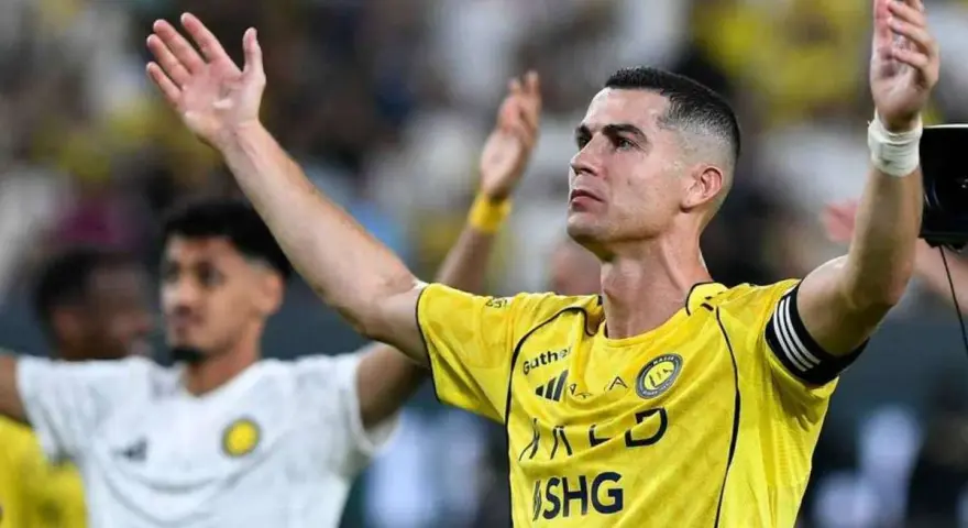 Cristiano Ronaldo w żółtej koszulce z podniesionymi rękami. Ile goli strzelił Ronaldo?