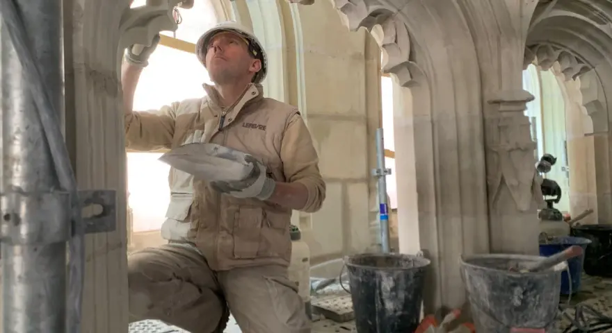 Un maçon restaure la voûte de la cathédrale de Nantes, un chantier qui suit l'incendie.