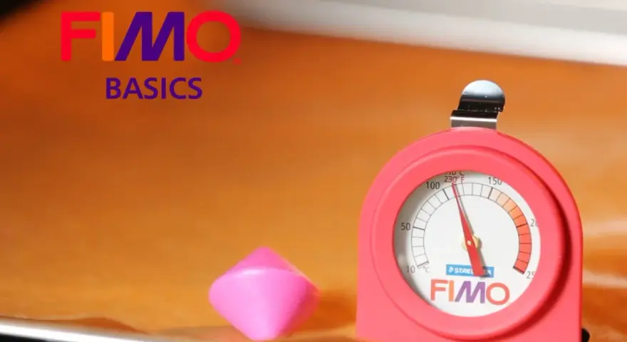 Termometro per forno per fimo, accanto a un pezzo di pasta modellabile rosa.
