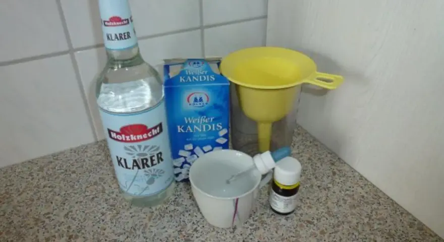 Zutaten für Ouzo selber machen: Klarer Schnaps, Kandiszucker, ein Trichter und eine Pipette.