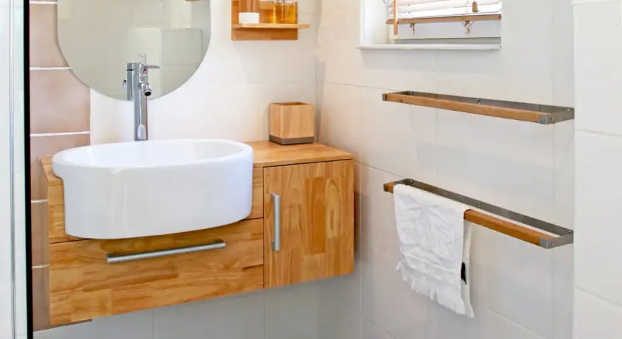 Meuble de salle de bain en bois clair, avec vasque blanche et robinetterie moderne. La hauteur du meuble est idéale pour un accès facile.