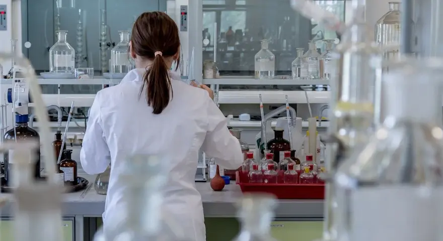 Naukowczyni w białym fartuchu pracuje w laboratorium chemicznym, przygotowując eksperyment. To kluczowy etap, jak otworzyć laboratorium chemiczne.