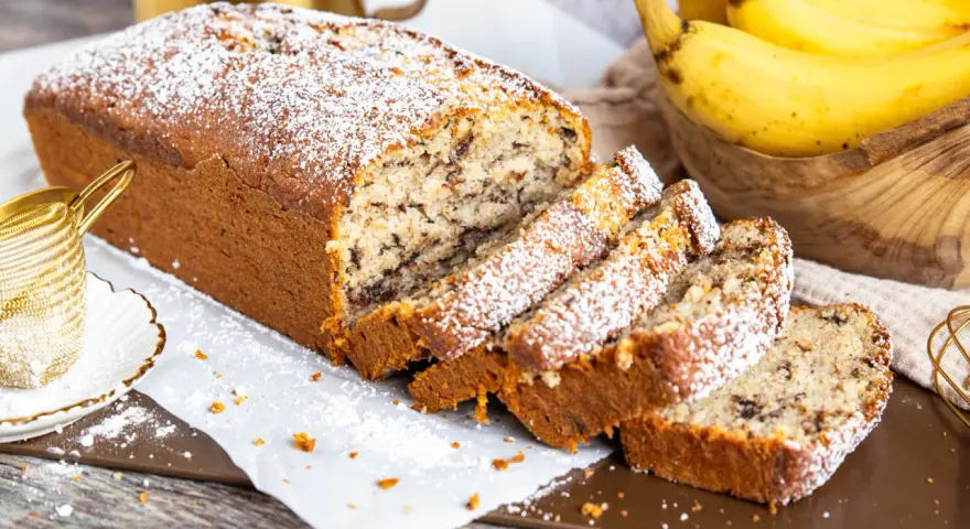 Saftiger Bananenkuchen mit Schokostückchen, bestäubt mit Puderzucker. Ein köstliches bananenkuchen rezept für jeden Anlass.