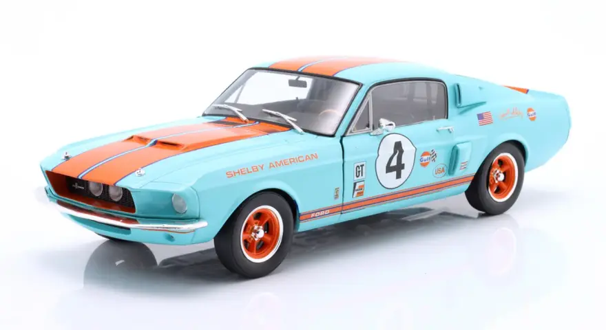 Błękitny Shelby GT z pomarańczowymi pasami i numerem 4, ozdobiony logotypami Gulf i USA.