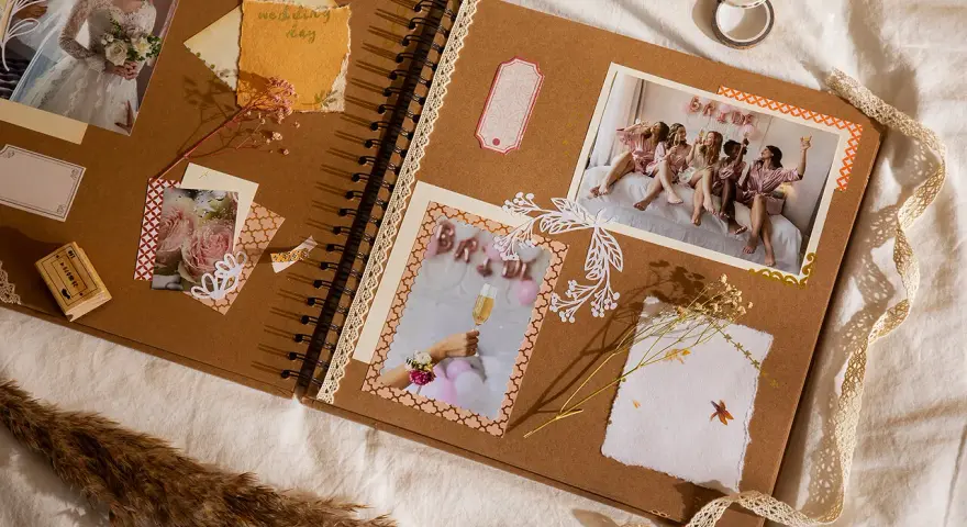 Otwarta księga wspomnień, gdzie co to jest scrapbooking widać na zdjęciach z wesela, ozdobiona wstążkami i suszonymi kwiatami.