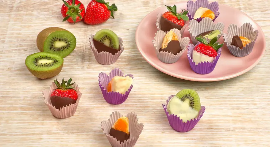 Fruktbitar doppade i choklad och vit choklad, serverade i färgglada cupcake formar. Jordgubbar, kiwi och apelsin.