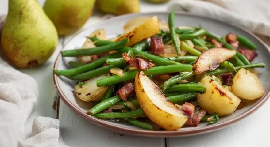 Ein Teller mit grünen Bohnen, Kartoffelspalten und knusprigem Speck. Dazu passen Birnen.